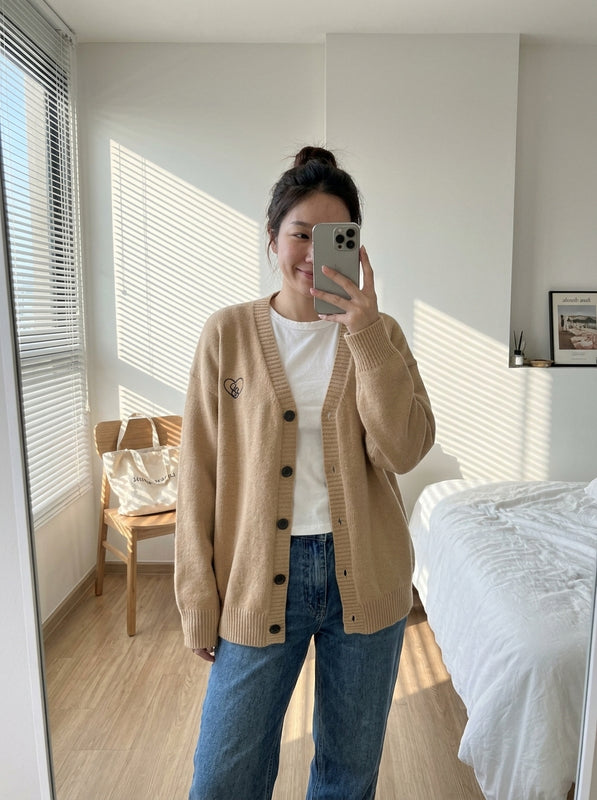 ภาพรีวิวจากคุณแพร สวมเสื้อคาร์ดิแกนปักหัวใจสี Warm Latte หน้ากระจกในคอนโด